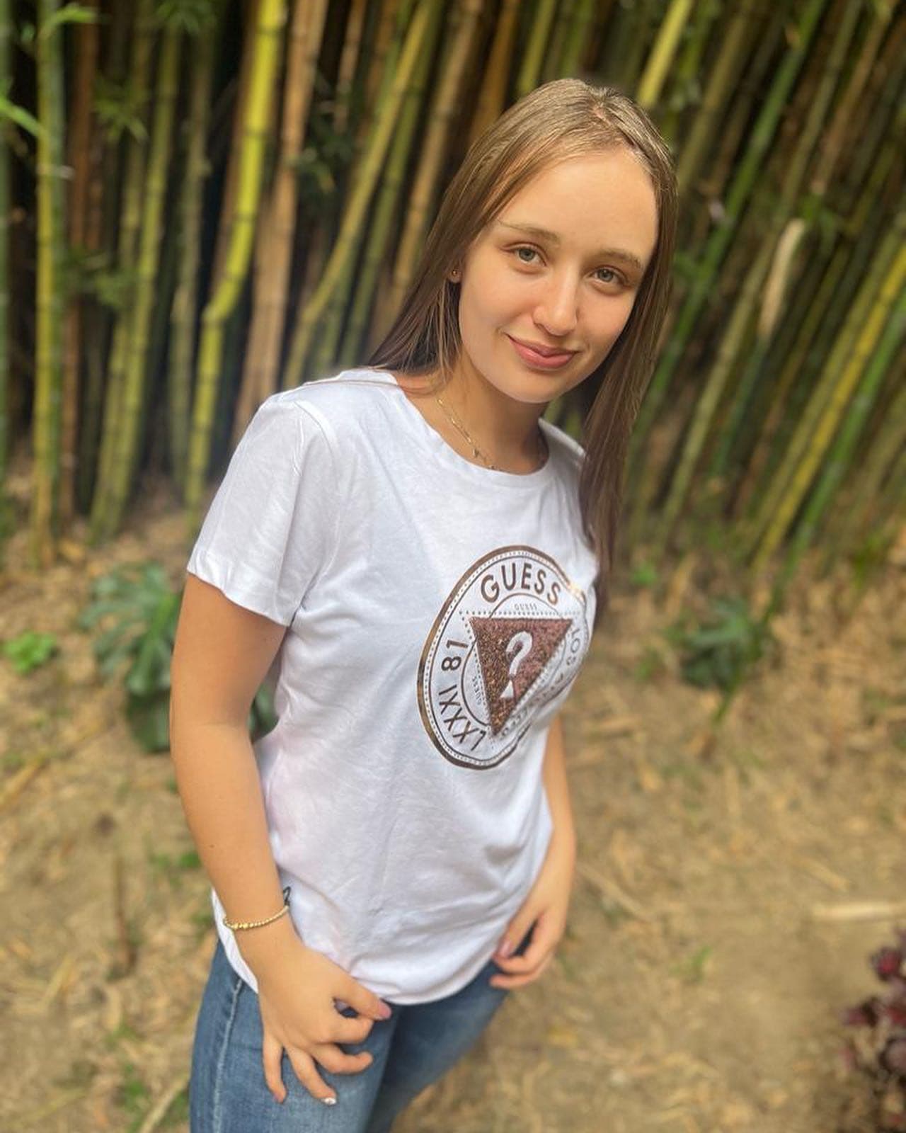 Camiseta Guess blanca de mujer con sello circular dorado LXXXI 81 Los Angeles y triángulo Guess, en modelo