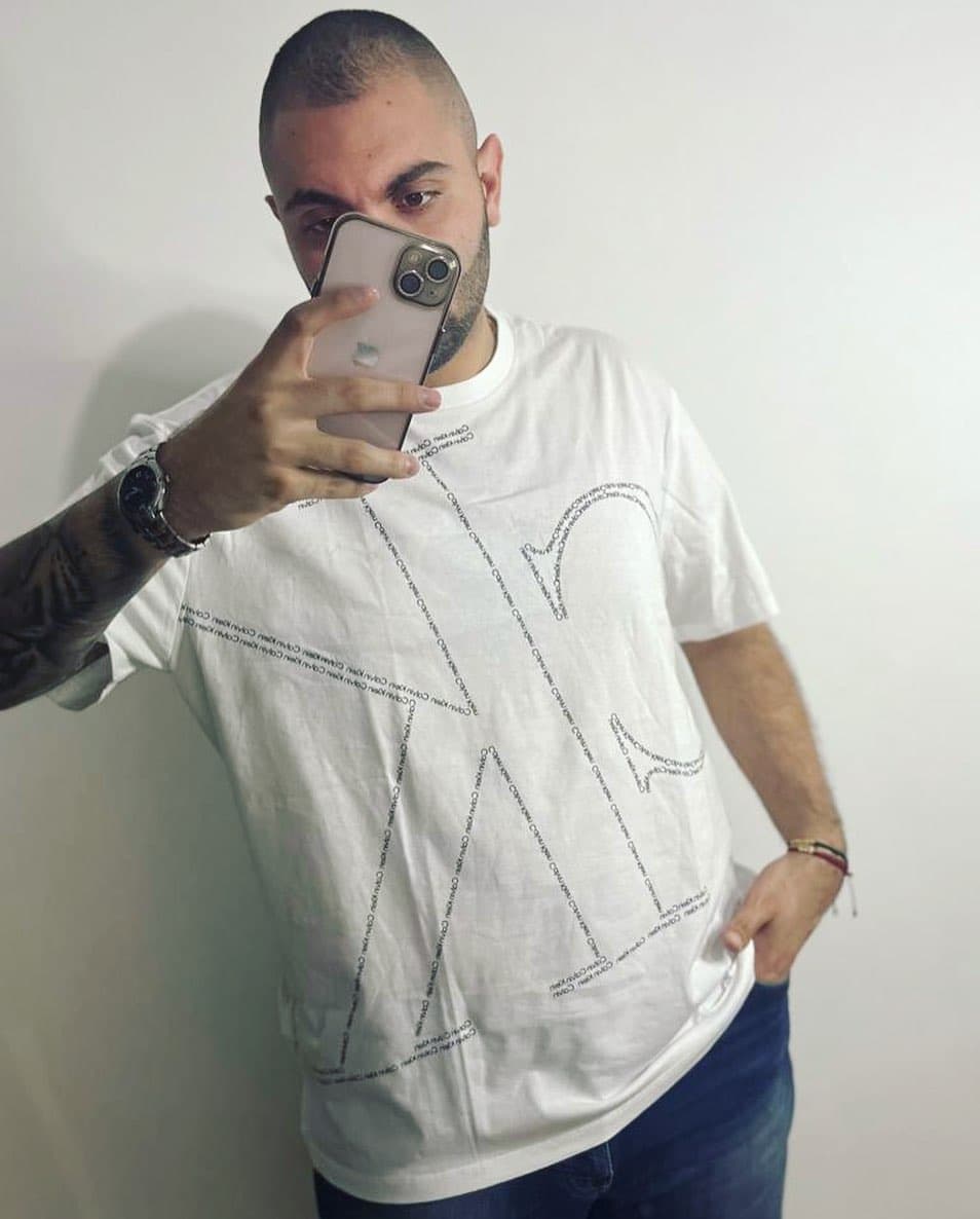 Camiseta Calvin Klein blanca oversized con monograma CK gigante formado por micro-texto tonal, en modelo